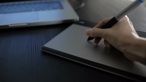 Hand Using Stylus on a Graphics Tablet