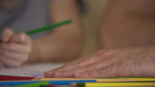 Nahaufnahme von Familienhänden, die farbenfrohe Bilder zeichnen, ein gemeinsames Wochenende genießen