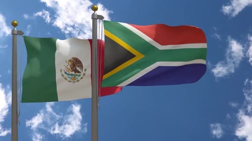 Mexico and South Africa National Flags Waving Against Blue Sky