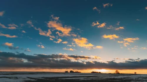 Winterwiesenfeld bei Sonnenuntergang am Abend. Natürliche helle, Dramatisch Himmelsfarben über der verschneiten Landschaft