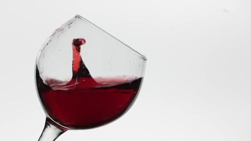 Close Up of a Drop Falling in Glass with Red Wine. Rose Wine on White Background
