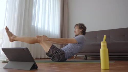 Man Doing Yoga Pose at Home on Tablet