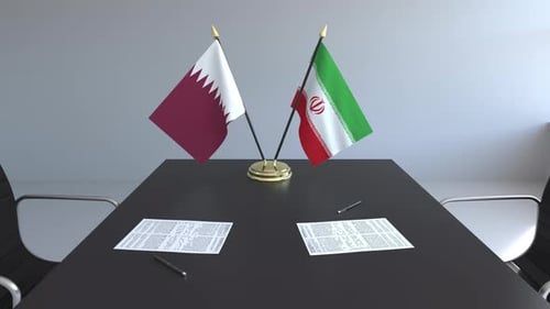 Diplomatic Meeting: Qatar and Iran Flags on Conference Table