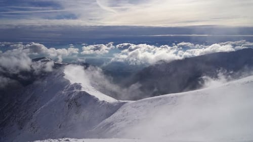 Snowy Alpine Mountains in Sunny Winter Above Clouds