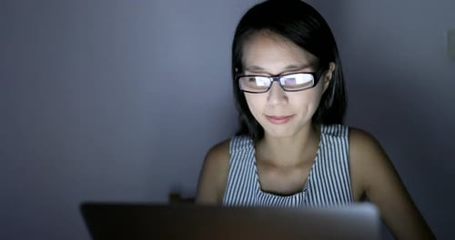 Frau fühlt sich müde, nachts einen Laptop zu benutzen