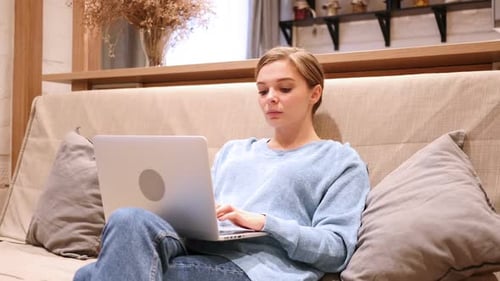 Woman Uses Laptop on Couch at Home