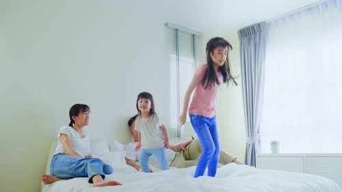 Happy Family Jumping on Bed Together at Home