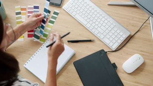 Visão de alto ângulo de uma jovem trabalhando com um tablet digitalizado desenhando em ambientes fechados no escritório