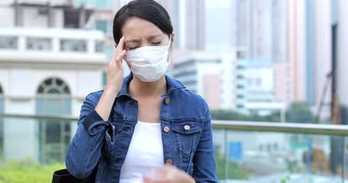 Woman Wearing a Face Mask with a Headache