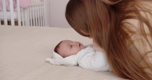 Loving Mother Bonding with Infant on Bed