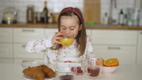 Young Girl Enjoying Breakfast at Kitchen Table