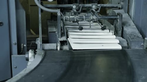 Empty blank white newspaper at the conveyor of a printing factory