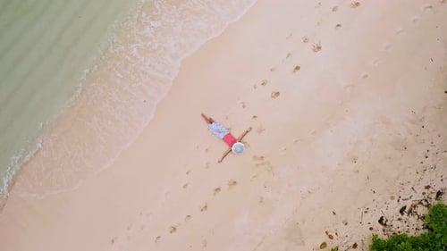 Aerial View Vertical Circle Move Up Footage From Girl Laying on a White Sand Beach Surrounded By