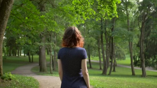 Middle View of Young Beautiful Girl, Unfolding Into the Camera in the Park