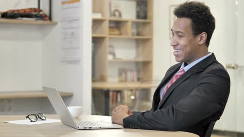 Young Man Talking on Video Call in Office