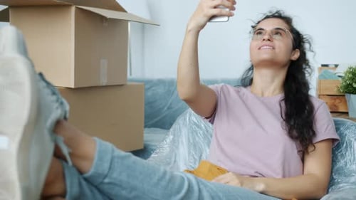 Woman Video Chatting Relaxing Among Moving Boxes