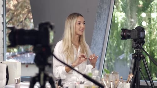 Una vloguera de belleza comenta su tutorial de maquillaje ante la cámara