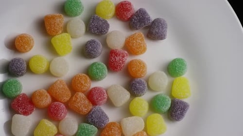 Bright Colorful Candies Scattered on White Plate