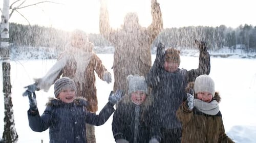 Family Posing and Tossing Up Snow
