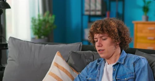 Young Man Relaxing on Couch with Remote