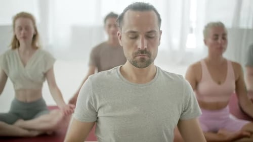 Yoga Class Meditating in Bright Studio