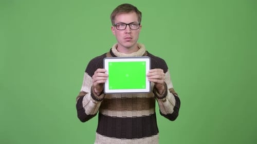 Young Handsome Man Thinking While Showing Digital Tablet