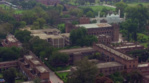 Vol aérien vers la belle mosquée blanche au-dessus des anciens bâtiments du patrimoine, entourée d'arbres verts