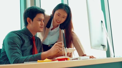 Two Business People Talk Project Strategy at Office