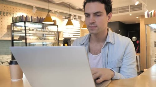 Young Man Upset By Loss of Trade Sitting in Cafe