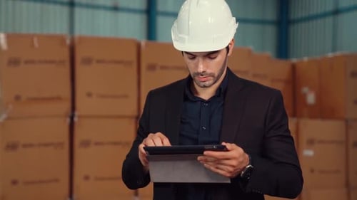 Factory Manager Using Tablet Computer in Warehouse or Factory