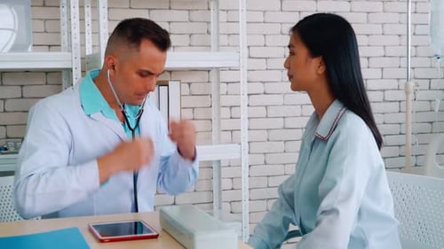 Doctor in Professional Uniform Examining Patient at Hospital
