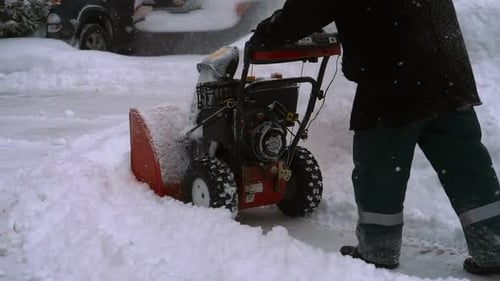 Man with a Snow Blowing Machine Working