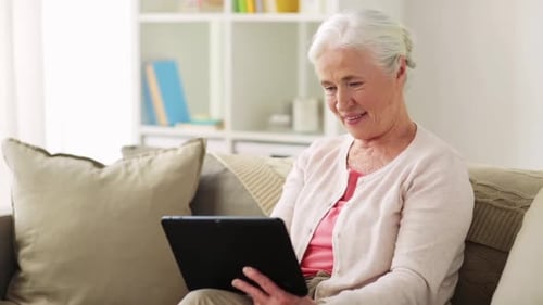 Happy Senior Woman with Tablet Computer at Home