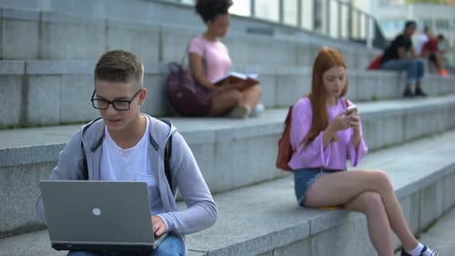 Concentrated High School Pupil Working Online Project Laptop, Playing Game