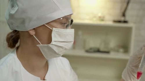 Médecin Femme en masque et lunettes en uniforme dans un laboratoire avec équipement