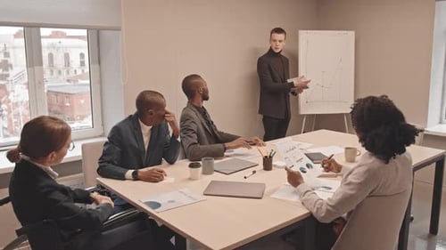 Man Presenting Graph to Colleagues