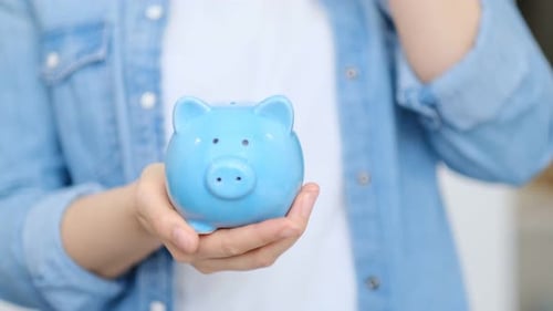 Hands Saving Money in Piggy Bank