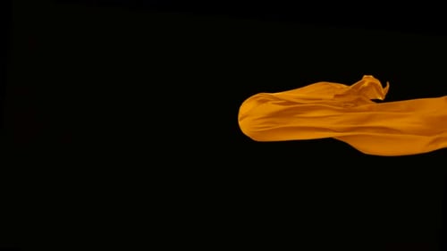 Orange fabric flowing on black background, Slow Motion