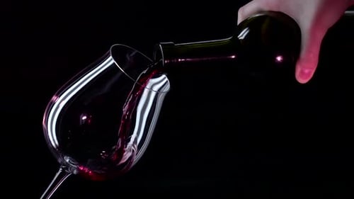 Pouring Red Wine into a Glass on Black