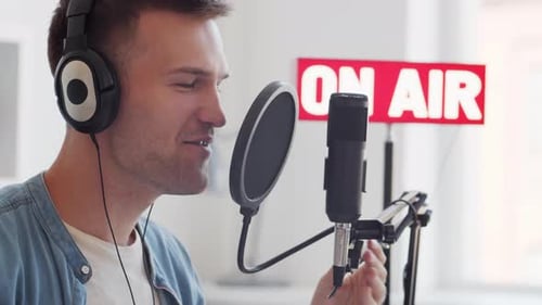 Man Puts on Headphones and Speaks Into Microphone