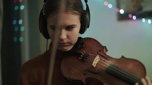 Woman Plays Violin with Headphones Indoors