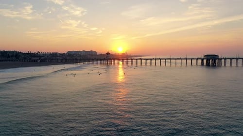 4k Sunrise drone at the famous Huntington Beach Pier in Surf City USA Southern California.