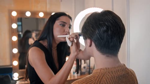 Woman Applying Makeup to a Person