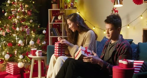 Loving Couple Opening Christmas Gifts at Home