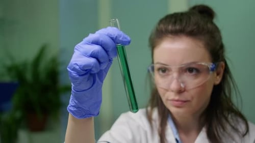 Scientist Analyzes Green Liquid in Test Tube