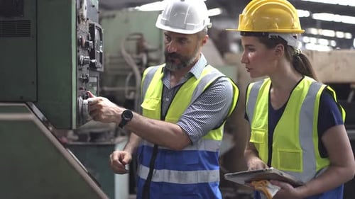 Engineers Collaborate on Industrial Machine Settings in Factory