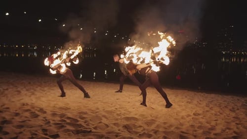 Performers Dance with Fire on Beach at Night