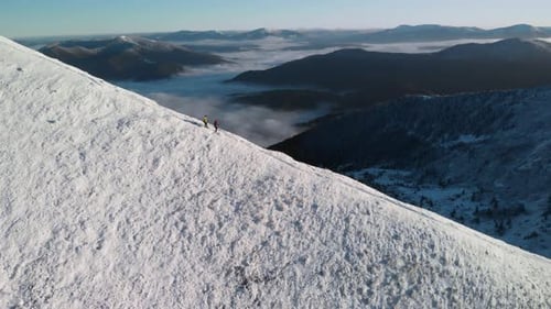 Two Hikers Descending a Mountain Ridge