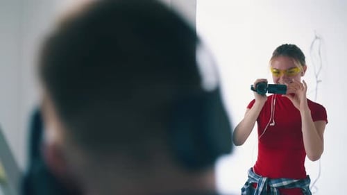 Woman with Video Camera Films Man Indoors