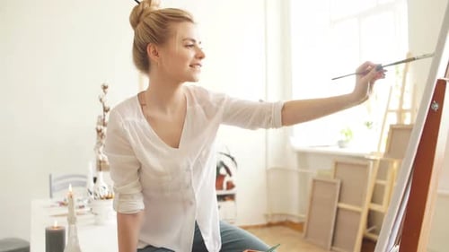 Young Woman Painting in Bright Art Studio